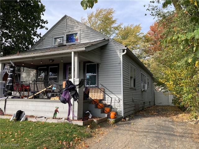 bungalow-style house featuring covered porch and cooling unit