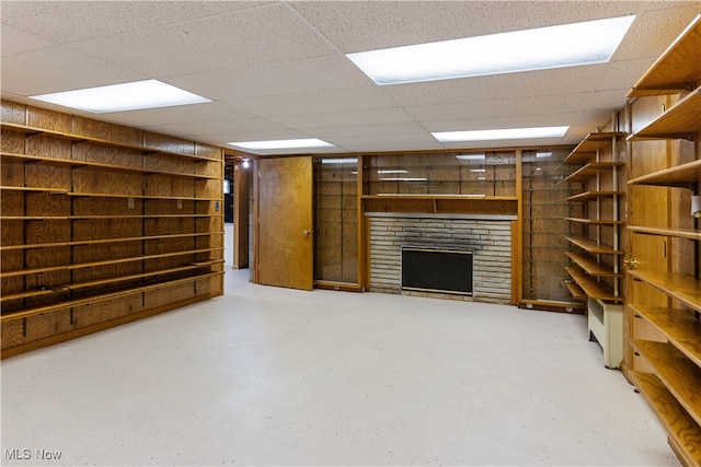 basement featuring a drop ceiling and a fireplace