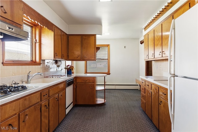 kitchen featuring baseboard heating, sink, tasteful backsplash, and white appliances