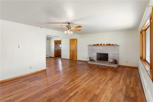 unfurnished living room featuring ceiling fan, a baseboard radiator, a fireplace, and hardwood / wood-style floors