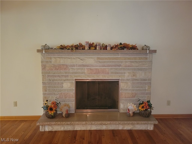 interior details featuring hardwood / wood-style floors and a stone fireplace