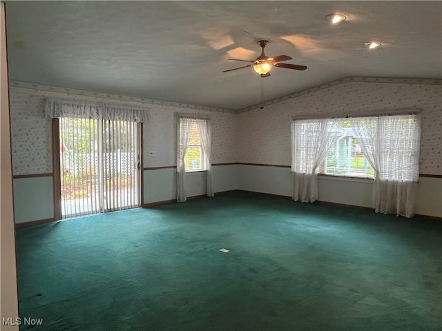 spare room with lofted ceiling, carpet floors, a textured ceiling, and ceiling fan