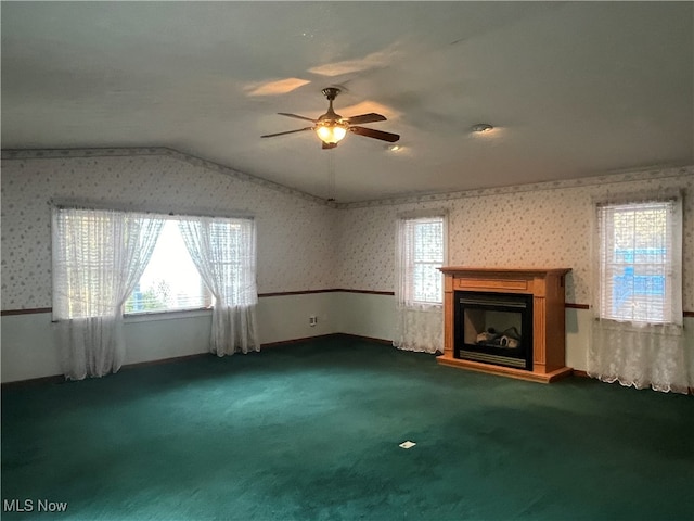 unfurnished living room with ceiling fan, a healthy amount of sunlight, carpet, and lofted ceiling