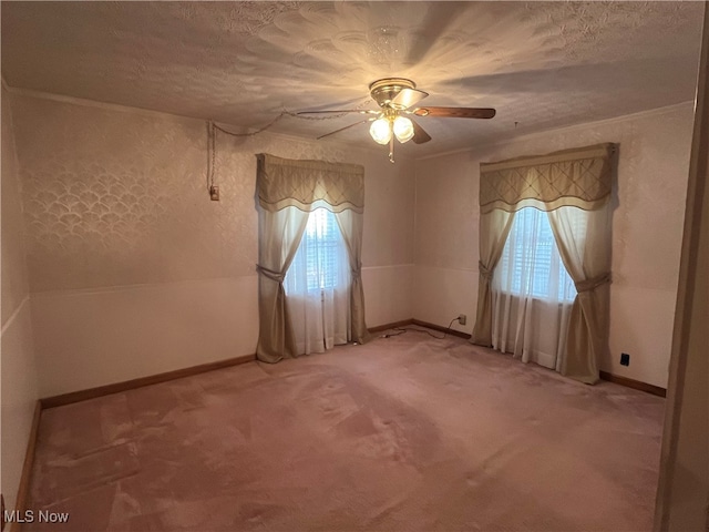 spare room with ceiling fan, a healthy amount of sunlight, a textured ceiling, and carpet floors