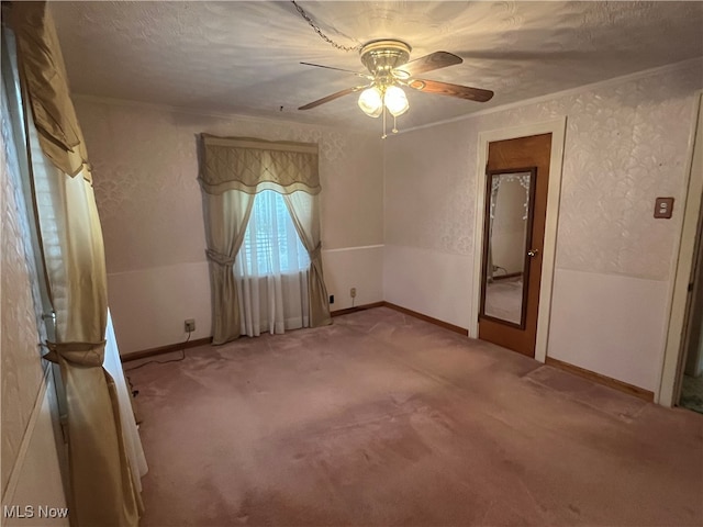 carpeted empty room with ornamental molding, a textured ceiling, and ceiling fan