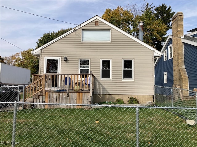 rear view of house featuring a deck and a lawn