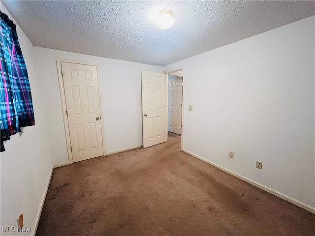 unfurnished bedroom featuring a textured ceiling and carpet flooring