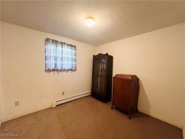 unfurnished bedroom featuring a baseboard heating unit, a textured ceiling, and carpet floors