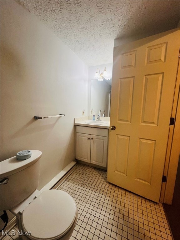 bathroom featuring vanity, toilet, tile patterned floors, and a textured ceiling