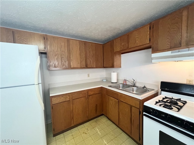 kitchen featuring a textured ceiling, sink, and white appliances