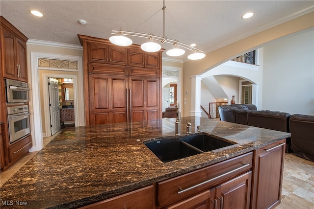 kitchen featuring dark stone countertops, a textured ceiling, ornamental molding, and sink