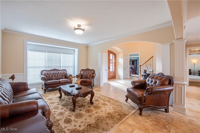 living room with ornamental molding and ornate columns