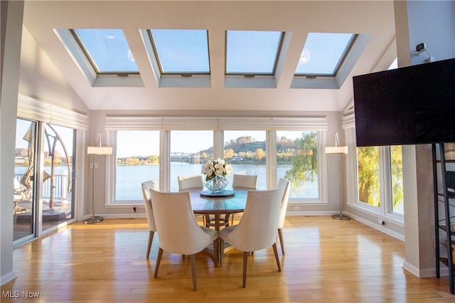 sunroom / solarium with lofted ceiling with skylight and a healthy amount of sunlight