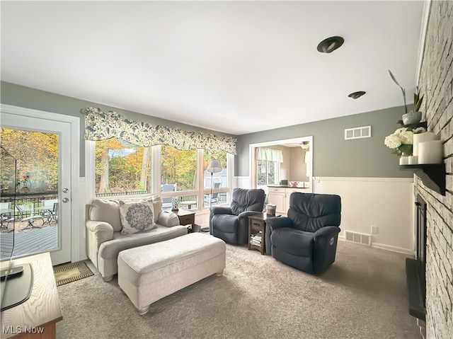 carpeted living room with a brick fireplace