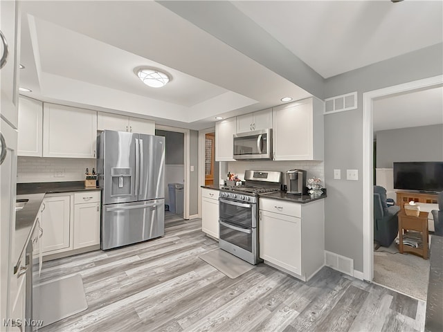 kitchen with light wood-type flooring, white cabinetry, and appliances with stainless steel finishes