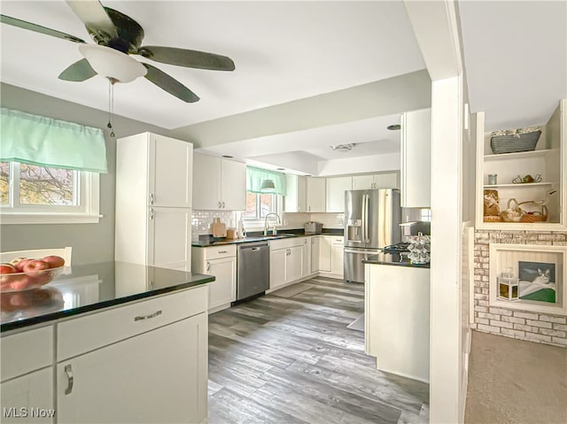 kitchen with backsplash, white cabinetry, sink, and stainless steel appliances