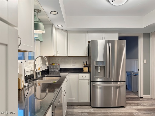 kitchen featuring white cabinetry, sink, stainless steel appliances, and light hardwood / wood-style floors