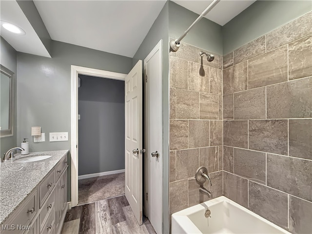 bathroom featuring vanity, wood-type flooring, and tiled shower / bath