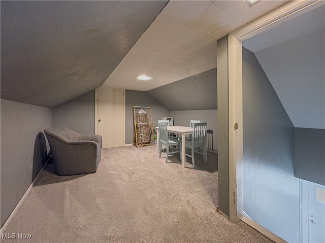 additional living space featuring lofted ceiling and light carpet