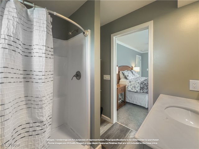 bathroom with hardwood / wood-style floors, a shower with curtain, ornamental molding, and sink