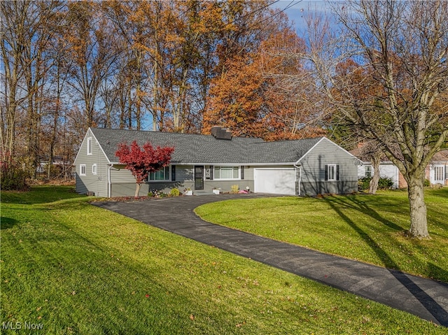 ranch-style home featuring a garage and a front lawn