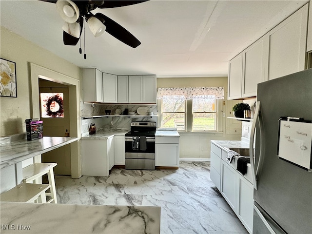 kitchen featuring white cabinetry, ceiling fan, stainless steel appliances, and backsplash