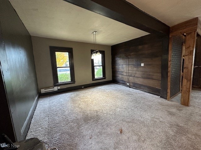 unfurnished dining area featuring beam ceiling, wooden walls, and carpet