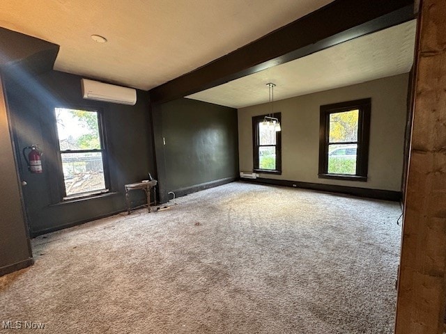 unfurnished room with beamed ceiling, carpet, and a wall mounted AC