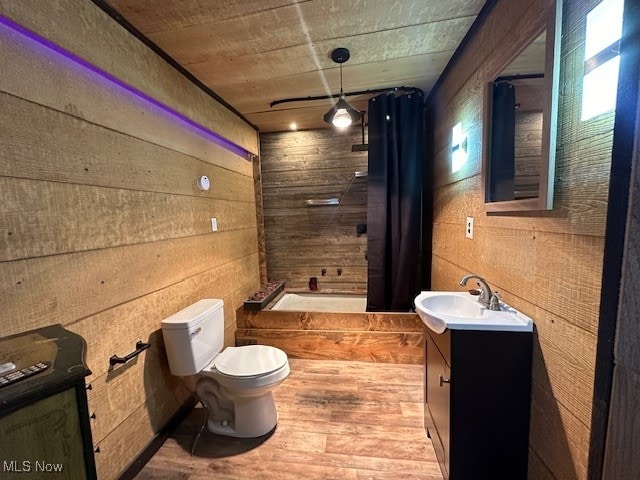 full bathroom with vanity, wood walls, shower / bath combo, hardwood / wood-style floors, and toilet