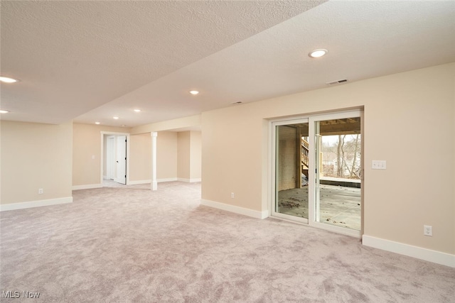 empty room featuring light colored carpet and a textured ceiling