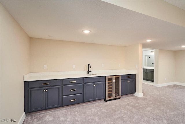 bar featuring wine cooler, sink, and light colored carpet