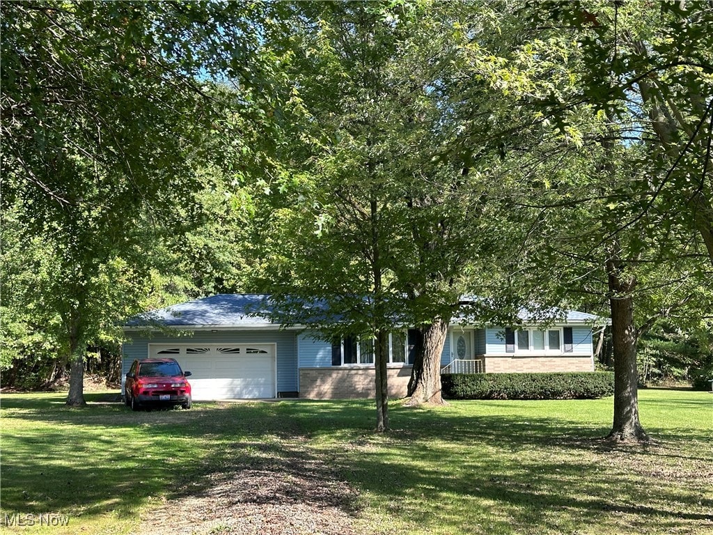 single story home featuring a front lawn and a garage