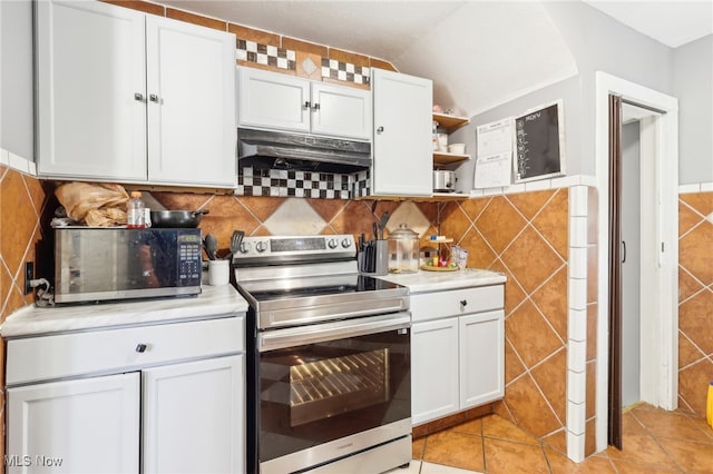 kitchen featuring lofted ceiling, white cabinets, light tile patterned flooring, tile walls, and appliances with stainless steel finishes