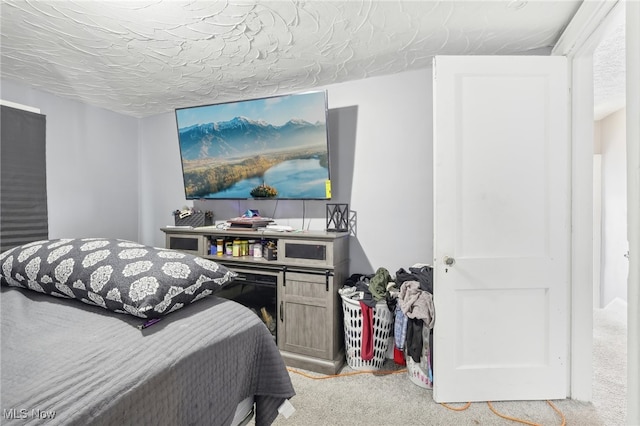 bedroom with a textured ceiling and light colored carpet