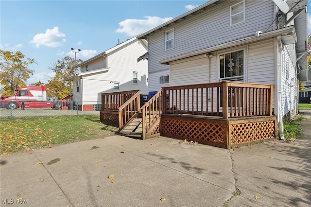 back of property featuring a patio, a deck, and a yard