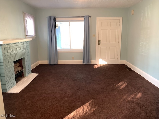 unfurnished living room featuring a textured ceiling, carpet flooring, and a fireplace