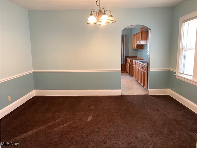 interior space featuring light carpet, a chandelier, sink, and pendant lighting