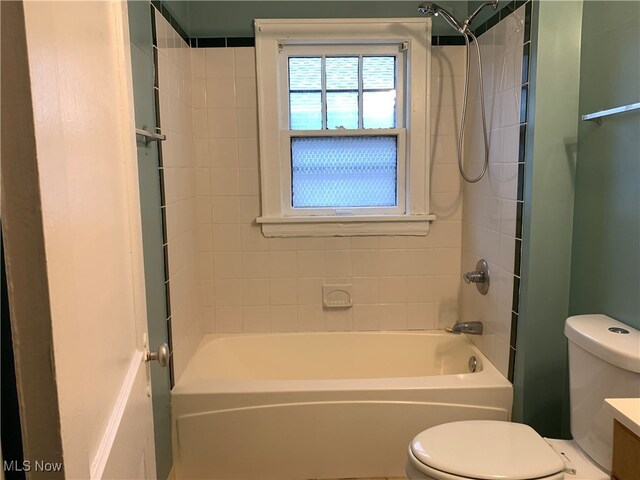 full bathroom with toilet, tiled shower / bath combo, and vanity