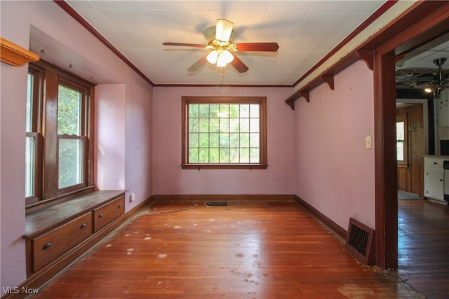 empty room featuring dark wood-type flooring, ceiling fan, and a healthy amount of sunlight