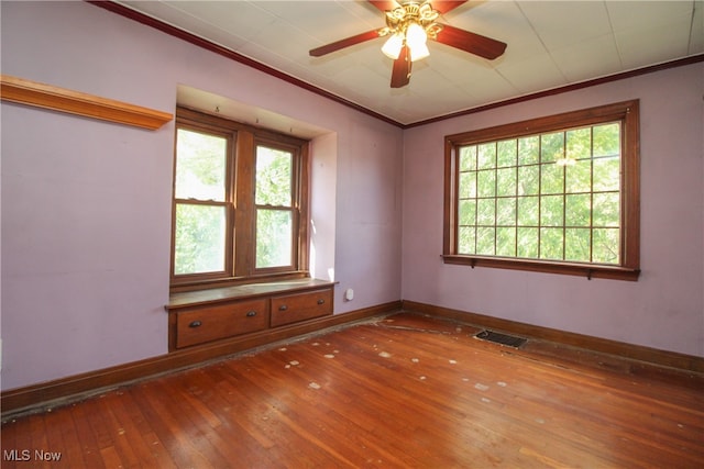 unfurnished room with ceiling fan, crown molding, wood-type flooring, and a wealth of natural light