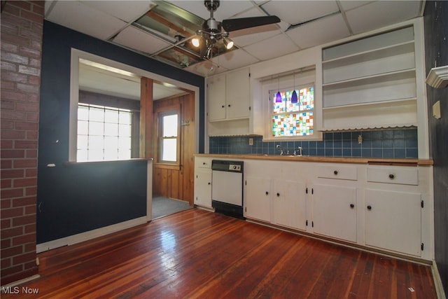 kitchen featuring decorative backsplash, dark wood-type flooring, white dishwasher, white cabinetry, and a paneled ceiling