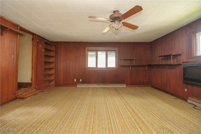 unfurnished living room featuring wood walls, a baseboard heating unit, and ceiling fan