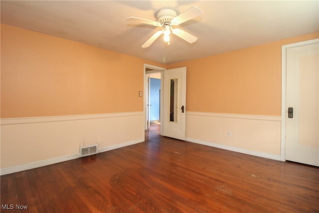 empty room featuring dark wood-type flooring and ceiling fan