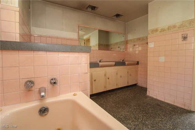 bathroom featuring vanity, tile walls, and a washtub