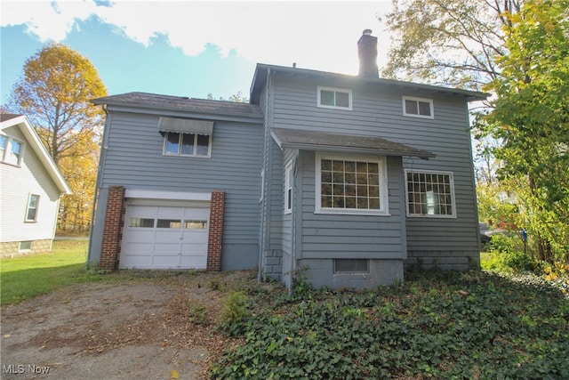 rear view of house with a garage