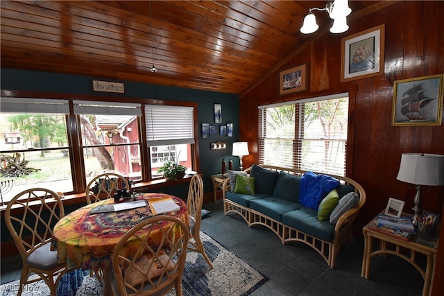 dining room with tile patterned floors, wood ceiling, lofted ceiling, and wood walls