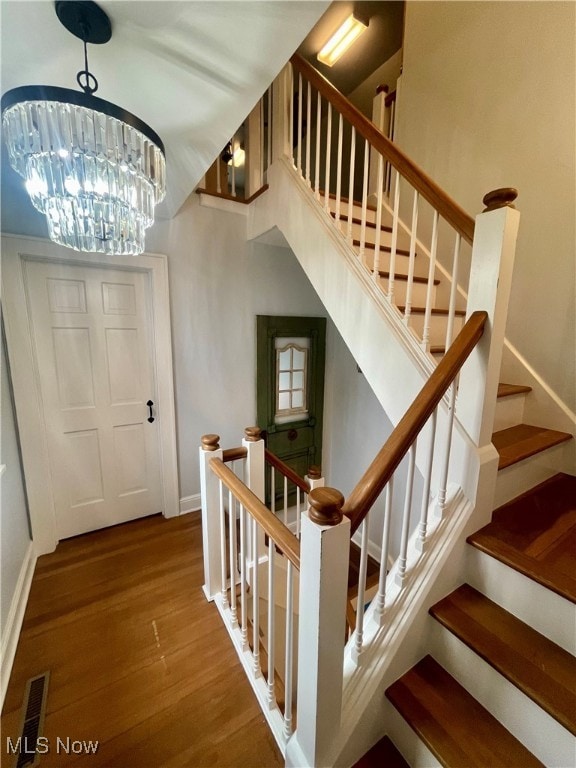 foyer entrance featuring hardwood / wood-style floors and an inviting chandelier