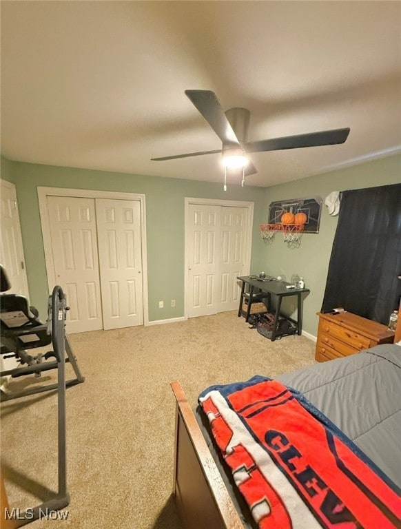 bedroom featuring ceiling fan, multiple closets, and carpet