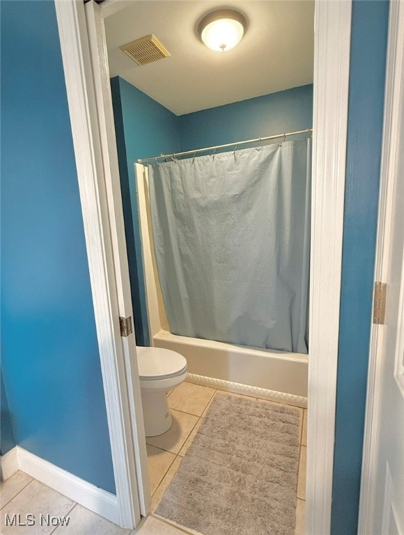 bathroom with shower / bath combo, toilet, and tile patterned flooring