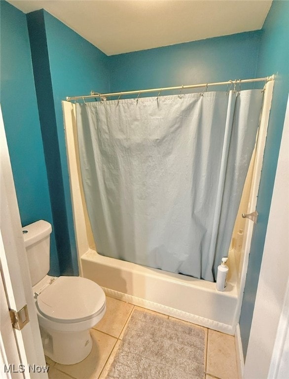 bathroom featuring toilet, shower / bath combo with shower curtain, and tile patterned floors